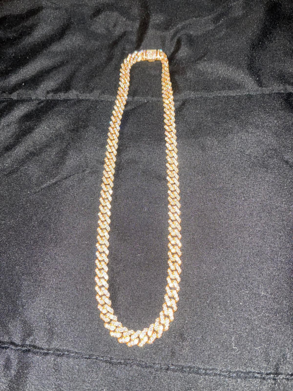Long Cuban link chain displayed on black fabric