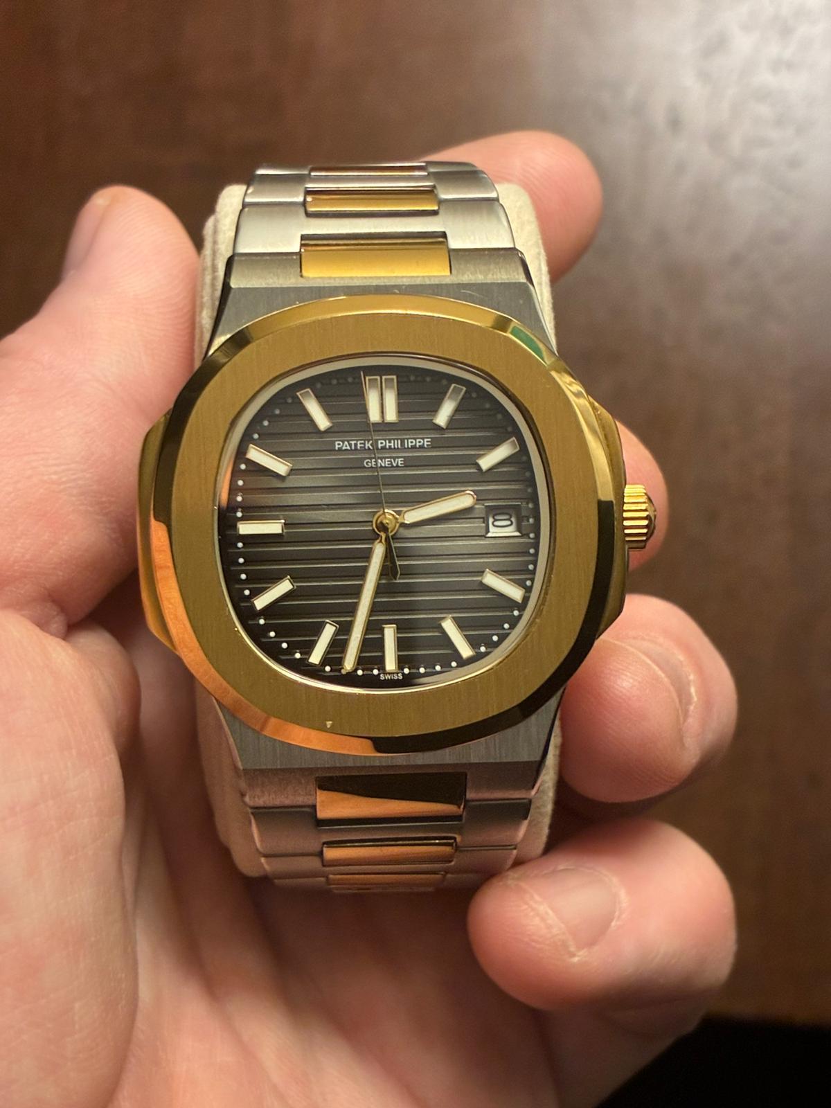 Two-tone Patek Philippe Nautilus held in a hand