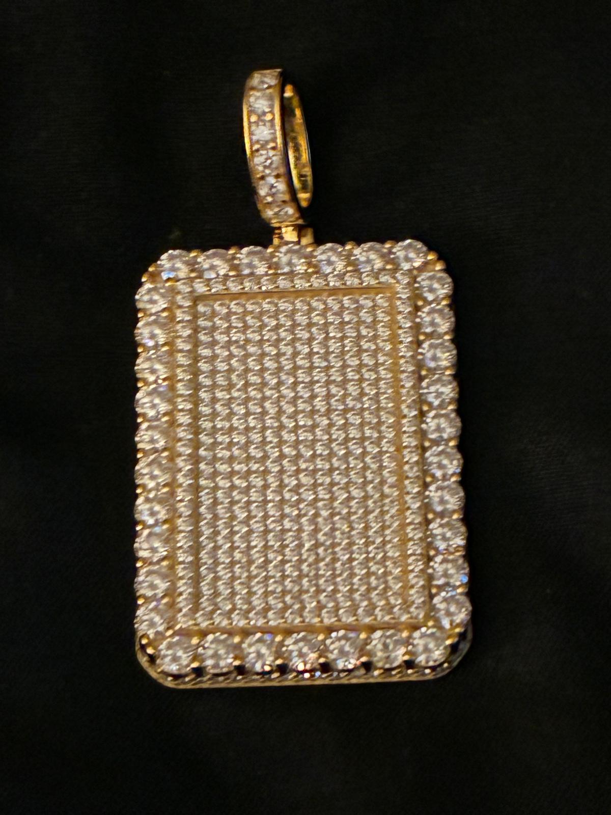 Gold dog tag pendant paved in diamonds resting on black velvet