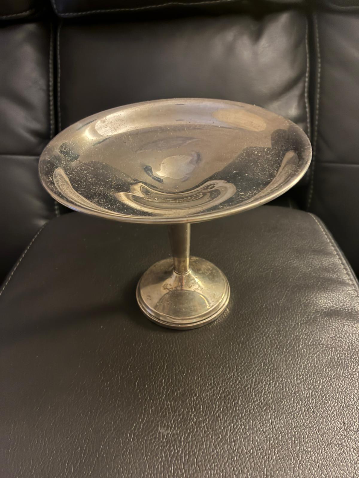 Sterling pedestal dish sitting on a leather chair